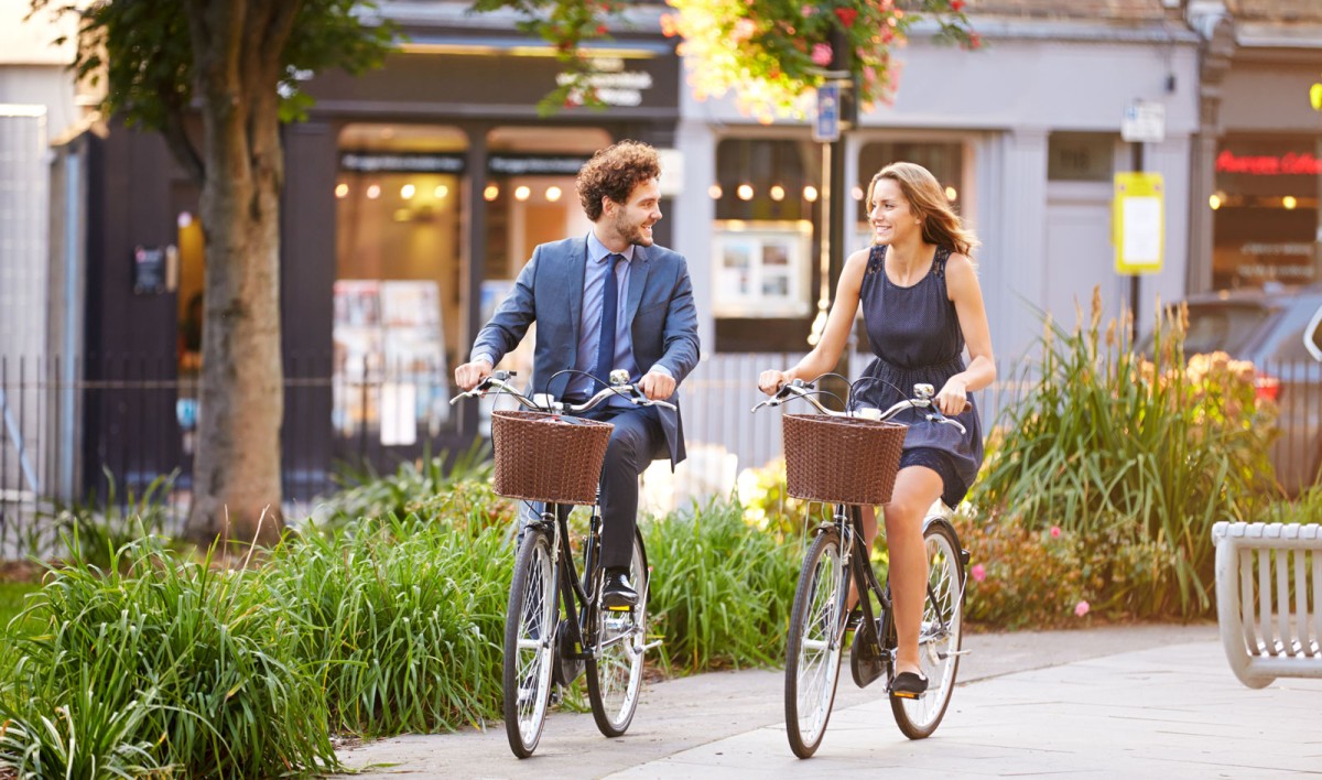 Frau und Mann auf Fahrrädern lächeln sich an